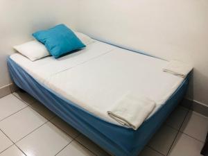 a bed with a blue pillow on top of it at Hostal Marysol in Puerto Ayora