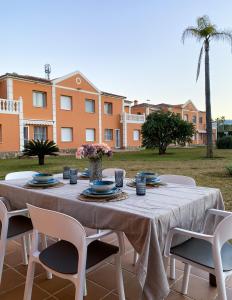 a table with chairs and a table with flowers on it at OLIVA NOVA GOLF BEACH & RESORT Club Sevilla V in Oliva