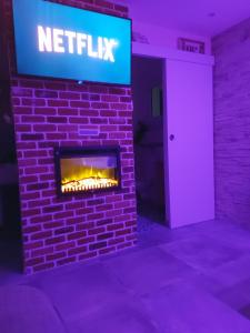 a brick fireplace with a sign that reads netflix at Les nids de la Baie in Favières +7 photos