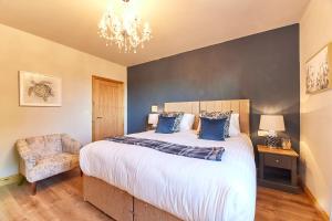 Un dormitorio con una cama grande y una lámpara de araña. en Host & Stay - High Bellridge Farm en Kirkheaton
