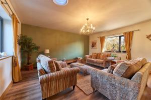 una sala de estar con sofás y una lámpara de araña. en Host & Stay - High Bellridge Farm en Kirkheaton