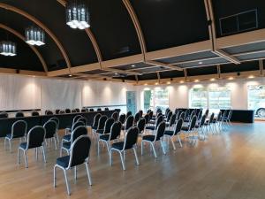 a large room with rows of chairs in it at Le Konine - Hotel & Bar & Restaurant in Montceau-les-Mines