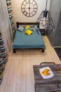 ein Schlafzimmer mit einem Bett mit einem Tisch und einer Uhr in der Unterkunft Weekend in Krasnojarsk