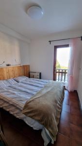 a bedroom with a large bed with a window at Appartamento immerso nella natura in Frontignano