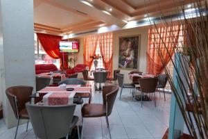 a dining room with tables and chairs in a restaurant at Hotel Lindi in Sarandë