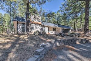 een huis in het bos met een stenen muur bij Ruidoso Getaway with Deck - 16 Mi to Ski Apache in Ruidoso