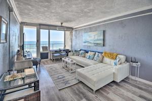 a living room with a white couch and a table at Bright Daytona Beach Condo with Community Pool! in Daytona Beach