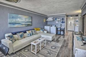 a living room with a couch and a kitchen at Bright Daytona Beach Condo with Community Pool! in Daytona Beach