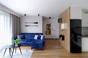salon z niebieską kanapą i stołem w obiekcie Apartament Marynarska Aquapark w Redzie