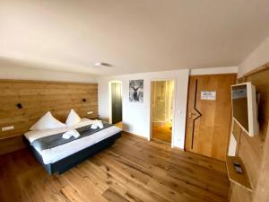 a bedroom with a bed in a room with wooden floors at Hotel Bergstätter Hof in Immenstadt im Allgäu