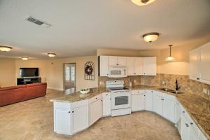 a large kitchen with white cabinets and appliances at Apt with Balconies - Steps to Kemah Boardwalk! in Kemah
