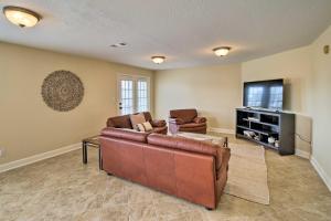 a living room with a couch and a flat screen tv at Apt with Balconies - Steps to Kemah Boardwalk! in Kemah