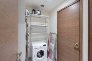 a laundry room with a washer and dryer next to a door at ON OFF HH-City walk- Relaxing design 2BR & MAID ROOM in Dubai