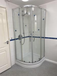 a shower in a bathroom with a glass shower stall at Stansted Airport Guest Rooms in Bishops Stortford