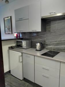 a kitchen with white cabinets and a counter top at ART STUDIO Airport Zagreb in Velika Gorica