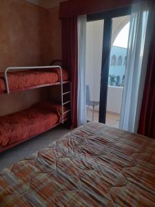 una camera da letto con due letti a castello e una finestra di Oasi Del Visir Resort a San Vito dei Normanni
