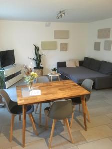 a living room with a wooden table and chairs at Souterrain Ferienwohnung im Acherner Weg in Achern +8 photos