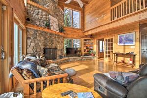 a living room with a stone fireplace in a cabin at Spacious Winhall Home about 1 Mi to Stratton Mtn! in Stratton Mountain