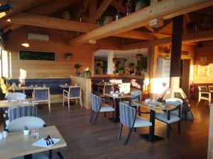 un restaurante con techos de madera, mesas y sillas en Le Konine - Hotel & Bar & Restaurant en Montceau-les-Mines