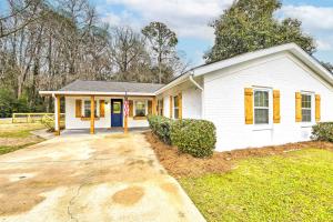a white house with yellow doors and a driveway at Bright Beaufort Home with Porch and Fire Pit! in Beaufort