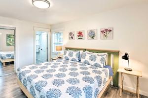 a bedroom with a bed with a blue and white comforter at Bright Beaufort Home with Porch and Fire Pit! in Beaufort