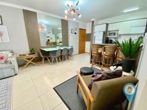 ein Wohnzimmer und eine Küche mit einem Sofa und einem Tisch in der Unterkunft Apto 3 Quartos em Home Club com telas de Proteção in Penha