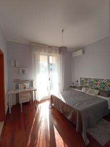 a bedroom with a bed and a table and a window at Baki B&B in Rimini