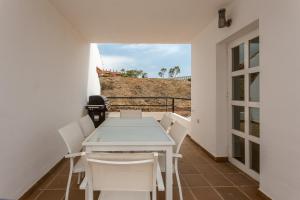 een tafel en stoelen op het balkon van een huis bij Manilva Townhouse with spectacular views of Gibraltar in Manilva