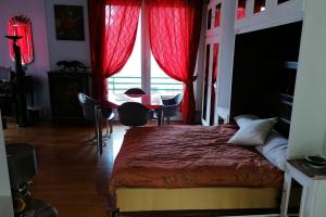 - une chambre avec un lit avec des rideaux rouges et une table dans l'établissement Le Fantasque City-center shops nearby T2 #H3, à Grenoble