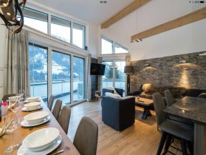 a living room with a table and chairs and a couch at Penthouse Alpendorf in Sankt Johann im Pongau