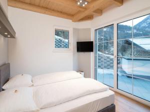 a bedroom with a bed and a large window at Penthouse Alpendorf in Sankt Johann im Pongau