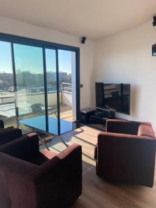 a living room with two couches and a tv at La Résidence Amal in Talence