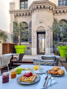 a table with waffles and fruit on top of it at Alex Hotel & Spa in Marseille
