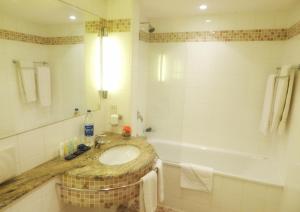 a bathroom with a sink, toilet and bathtub at The Federal Palace Hotel and Casino in Lagos