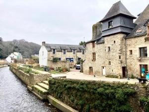 a group of buildings next to a river at SUITE KASSIOPEE, romantisme, balnéo, sauna in Quimperlé