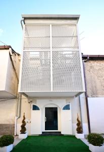 a house with white doors and a green lawn at Le Comprese - B&b Experience in Battipaglia