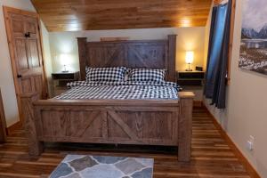 ein Schlafzimmer mit einem Holzbett mit zwei Kissen in der Unterkunft NEW!! House Near Raystown Lake in Peaceful Wooded Area in Huntingdon