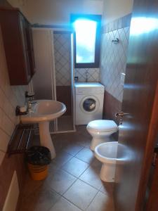 bagno con servizi igienici, lavandino e lavatrice di Oasi Del Visir Resort a San Vito dei Normanni