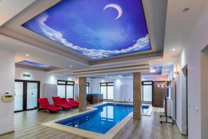 a living room with a pool and a ceiling with a painting at Pensiunea Paradisul Verde in Moisei +97 photos