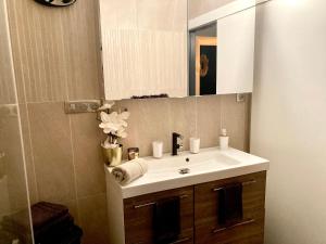 a bathroom with a white sink and a mirror at SUITE KASSIOPEE, romantisme, balnéo, sauna in Quimperlé +44 photos