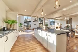 a large kitchen with white cabinets and a large island at Host & Stay - High Bellridge Farm in Kirkheaton