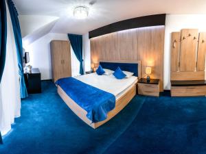 a bedroom with a large bed and blue carpet at Pensiunea Paradisul Verde in Moisei