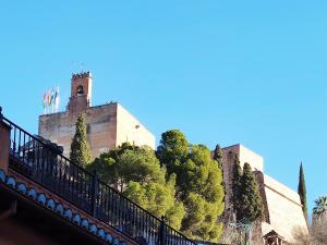 格拉納達的住宿－Precioso apartamento al lado de la Alhambra，山顶上一座有塔的建筑