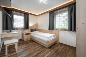 a bedroom with a bed and a desk at Obergasserhof in Rodengo