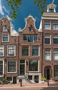 an apartment building in amsterdam with a pointed roof at de Bloemgracht in Amsterdam