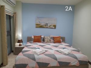 a bedroom with a bed with a checkered blanket at Seabreeze Guest Rooms in St Paul's Bay