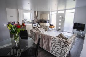 a living room with a couch and a table with flowers on it at Shepherd's Rest Apartments Central Location With Parking in Tewkesbury