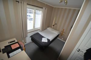 a small room with a bed and a window at Gästis Tierp in Tierp