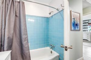 a blue tiled bathroom with a tub and a toilet at 1470 Barbara in Charleston +23 photos