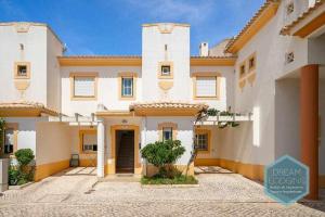 a large white house with a courtyard in front of it at Vila Sul Dream Lodging in Albufeira